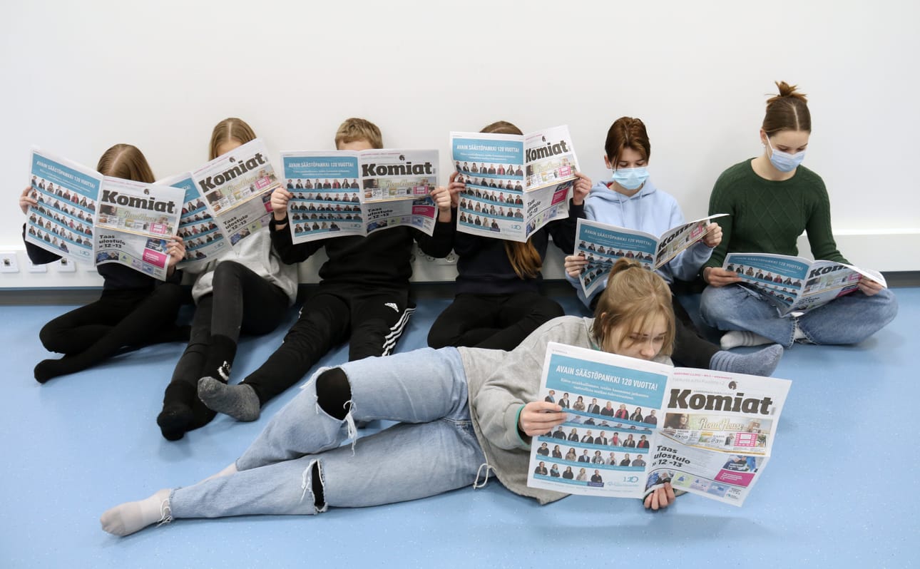 8.-luokkalaiset Ella Ekola, Neea Leskelä, Johannes Mäki-Haapoja, Hilla Perkiö, Kalle Latvala, Aura Hurtamo ja Martta Jussinmäki suopuivat kuvaajan ideaan ja tutkivat porukalla uusinta Komiat-lehteä lattialla istuen.