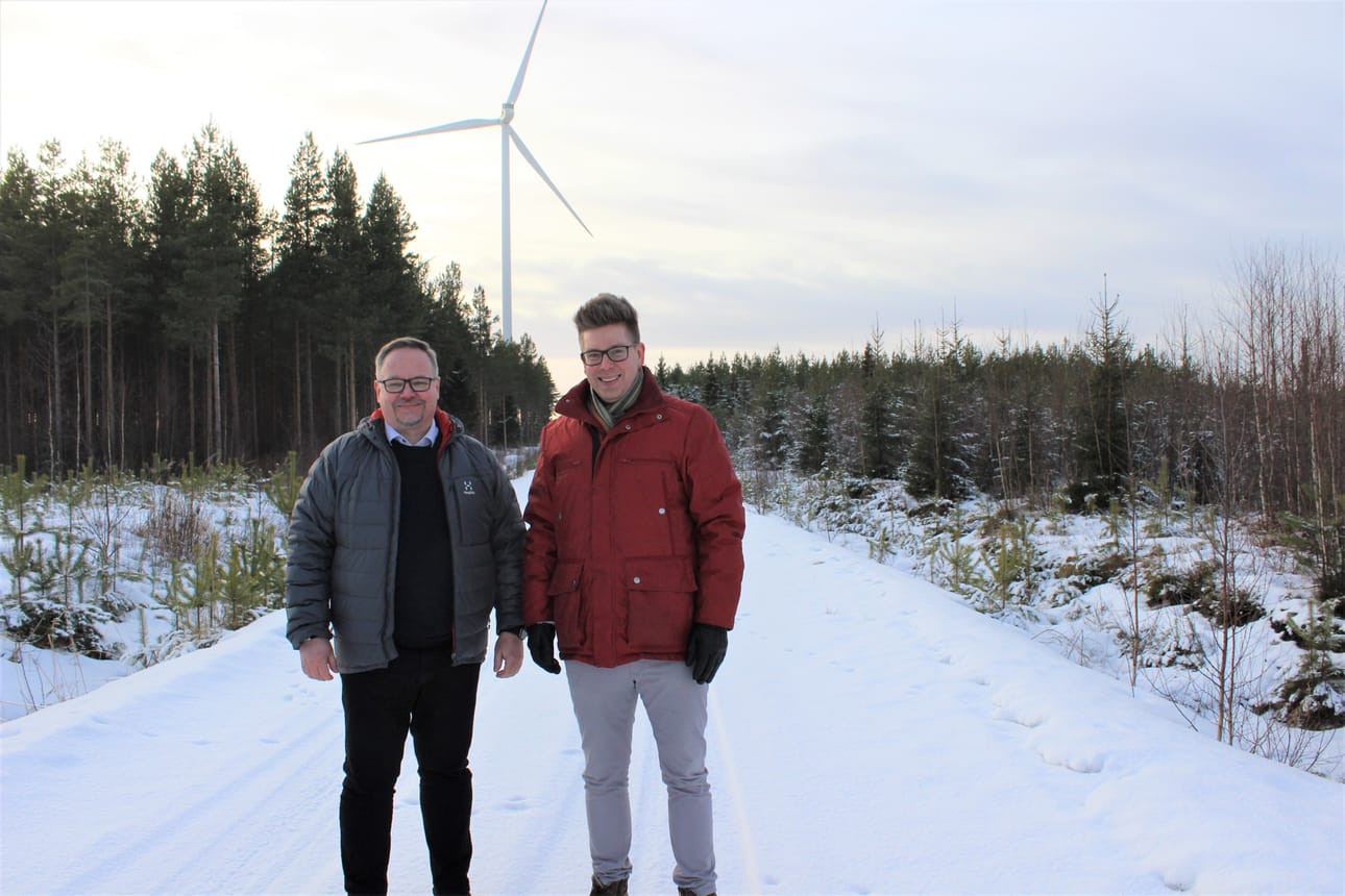 Karijoen kunnanjohtaja Marko Keski-Sikkilä ja Isojoen kunnanjohtaja Juha Herrala Lakiakankaalla. Taustan tuulivoimala viuhuu Karijoella puolella Ohrikylässä.