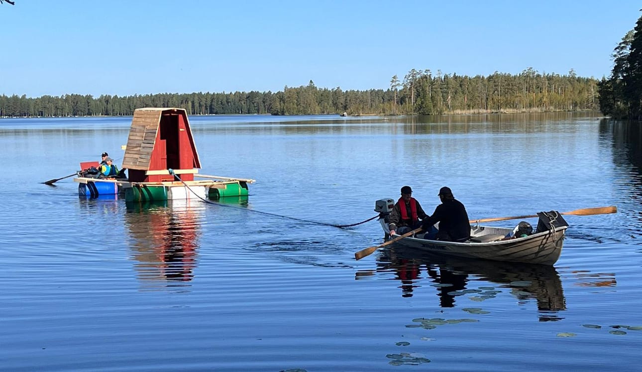 Saattue sai tehdä reissunsa tyynessä, aurinkoisessa säässä. Vesillelaskussa oli apuna traktori, päätepisteessä huussi siirtyi rannasta perille miesvoimin.