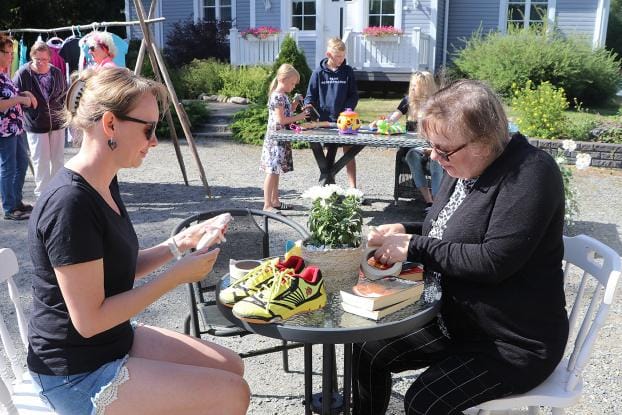 Piia Kivinen ja Katri Aho hinnoittelivat myyntiin meneviä tavaroita. Tuikantien kirppispäivään valmistautuivat myös Kivisen lapset sekä Pirkko Lammi, Anneli Pessinen ja Kerttu Kautiainen. KUVA: SAILA COLLANDER