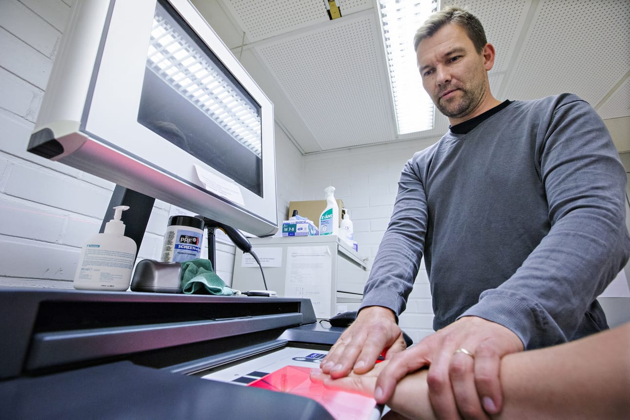 Turvapaikkahakemusta jätettäessä hakija rekisteröidään tietojärjestelmään. Rikosylikonstaapeli Risto Ottavainen ottaa hakijalta sormenjäljet ja myös kuvaa hänet.