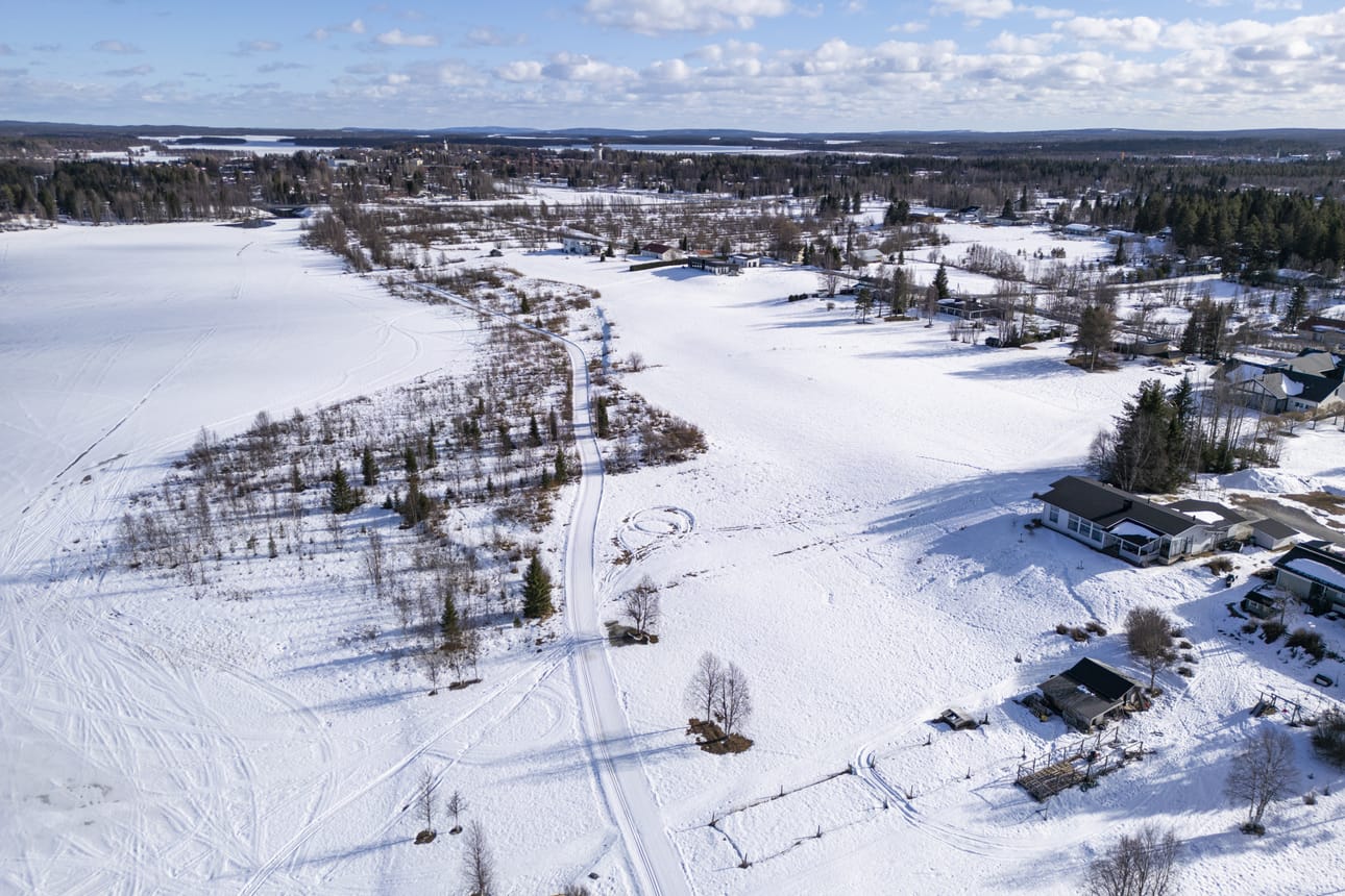 Kuusamon kirkonkylän yleiskaavatyössä muun muassa arvioidaan vakituisen asutuksen laajennustarpeita usealla puolella ydinkeskustaa, kuten täällä Leskelän alueella. Kuvassa vasemmalla on Nilon- eli Leskelänjärvi, keskellä keskustan ympäryslatu ja oikealla Leskeläntien varren omakotitaloja.