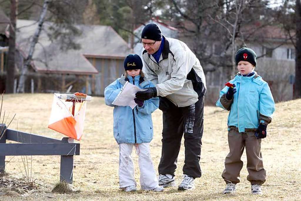 Essi Holma katsoo karttaa yhdessä isänsä Erkin ja veljensä Santerin kanssa.