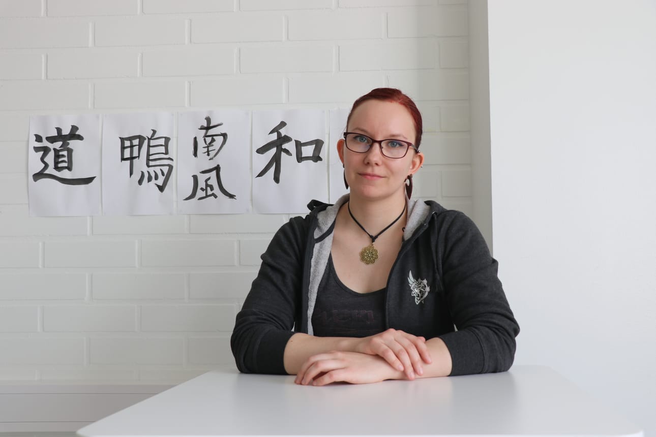 Alajärvellä ja Vimpelissä japania, venäjää ja englantia opettava Emmi Seppälä innostui japanista yläasteikäisenä harrastuksen kautta. Taustalla on hänen opiskelijoidensa tekemää kalligrafiataidetta.