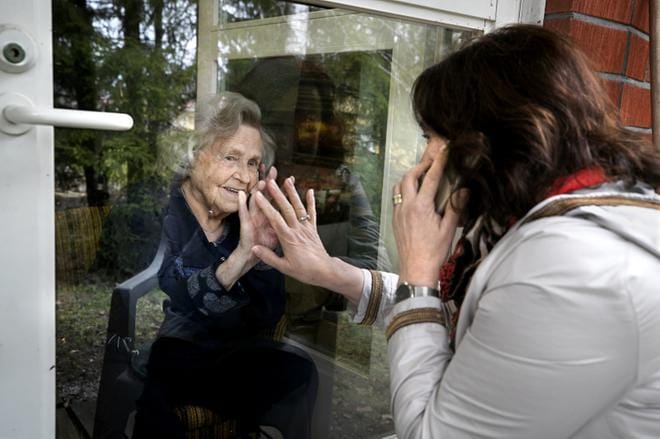 Korona teki äitienpäivästä erilaisen ja jopa sydäntä särkevän. Kauhajokelainen Raija Saarivirta-Kut kävi tapaamassa äitiään Helmi Saarivirtaa hoitokodissa. Vierailukiellon takia juttelu tapahtui puhelimitse terassin lasioven läpi. Kuva: Jouko Hänninen