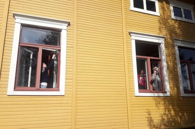 Ulla Anttila ja muut talkoolaiset pesivät talkoilla Lehtimäen vanhan pappilan ikkunoita Fagerkullafestiä varten.