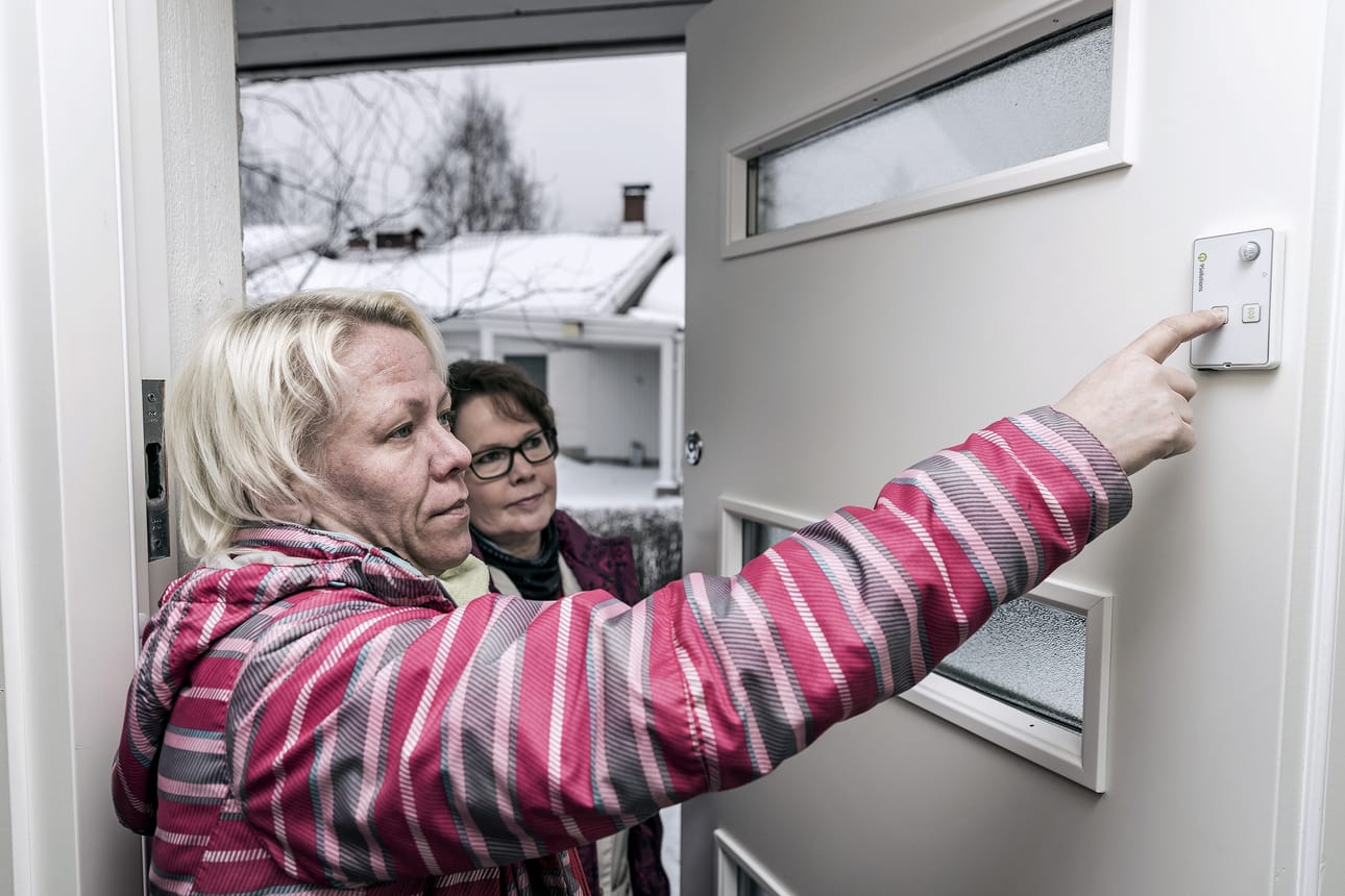 Päivi Kantanen-Tuppurainen (vas.) ja Mervi Parkkinen turvapartiosta katsastavat uudenlaista ovihälytintä. Laite tunnistaa, käykö vanhus vain kurkkimassa ovesta vai lähteekö hän ulos.
