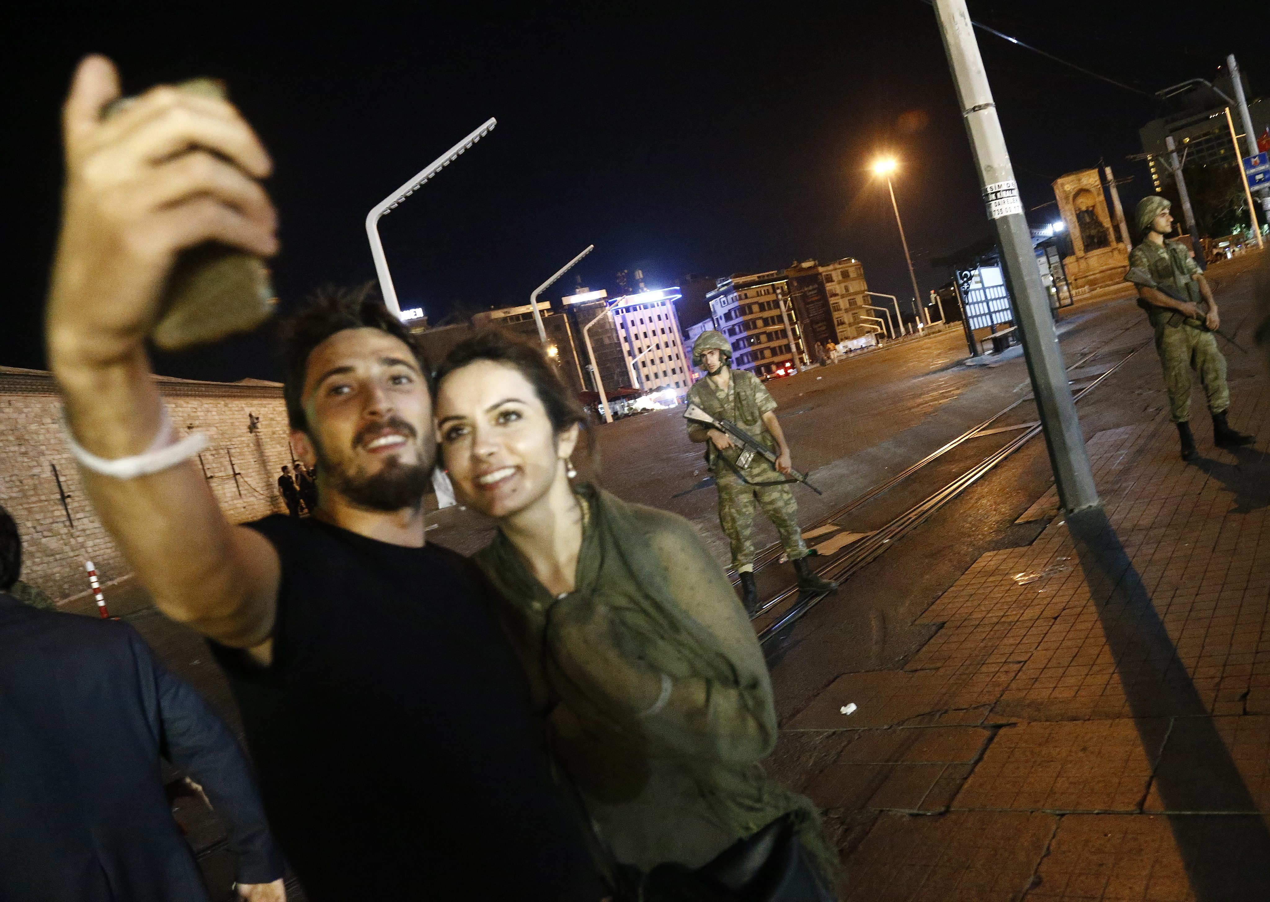 Recep Tayyip Erdoganin kannattajat ottivat selfieitä Taksim-aukiolla Istanbulissa ulkonaliikkumiskiellosta huolimatta. 