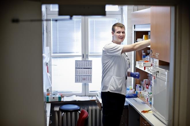 Joel Hjerpen työtehtäviin kuuluu muun muassa potilaiden voinnin seuraamista ja lääkkeiden jakamista. KUVA: TOMI KOSONEN