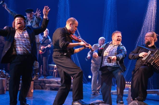 Kyösti Järvelä (keskellä) ja Antti Paalanen Kiharakolmio-yhtyeineen lyövät tahtia ja näyttelijät Tuomas Uusitalo, Taneli Mäkelä, Esko Roine ja Puntti Valtonen seuraavat perässä. Viulisti Järvelä tuuraa yhtyeessä Timo Saukkoa näytelmän ajan. KUVA: KARI SUNNARI