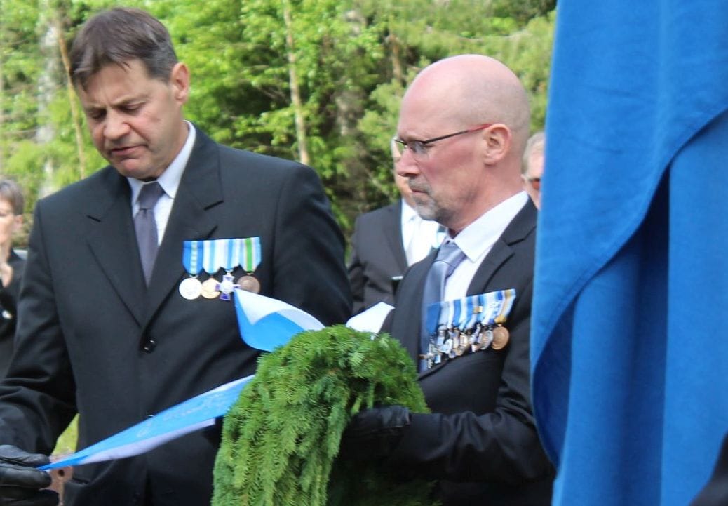 Jarmo Kivimäki laskee Ylihärmän reserviupseerien seppeleen. Vieressä Mika Mäki.