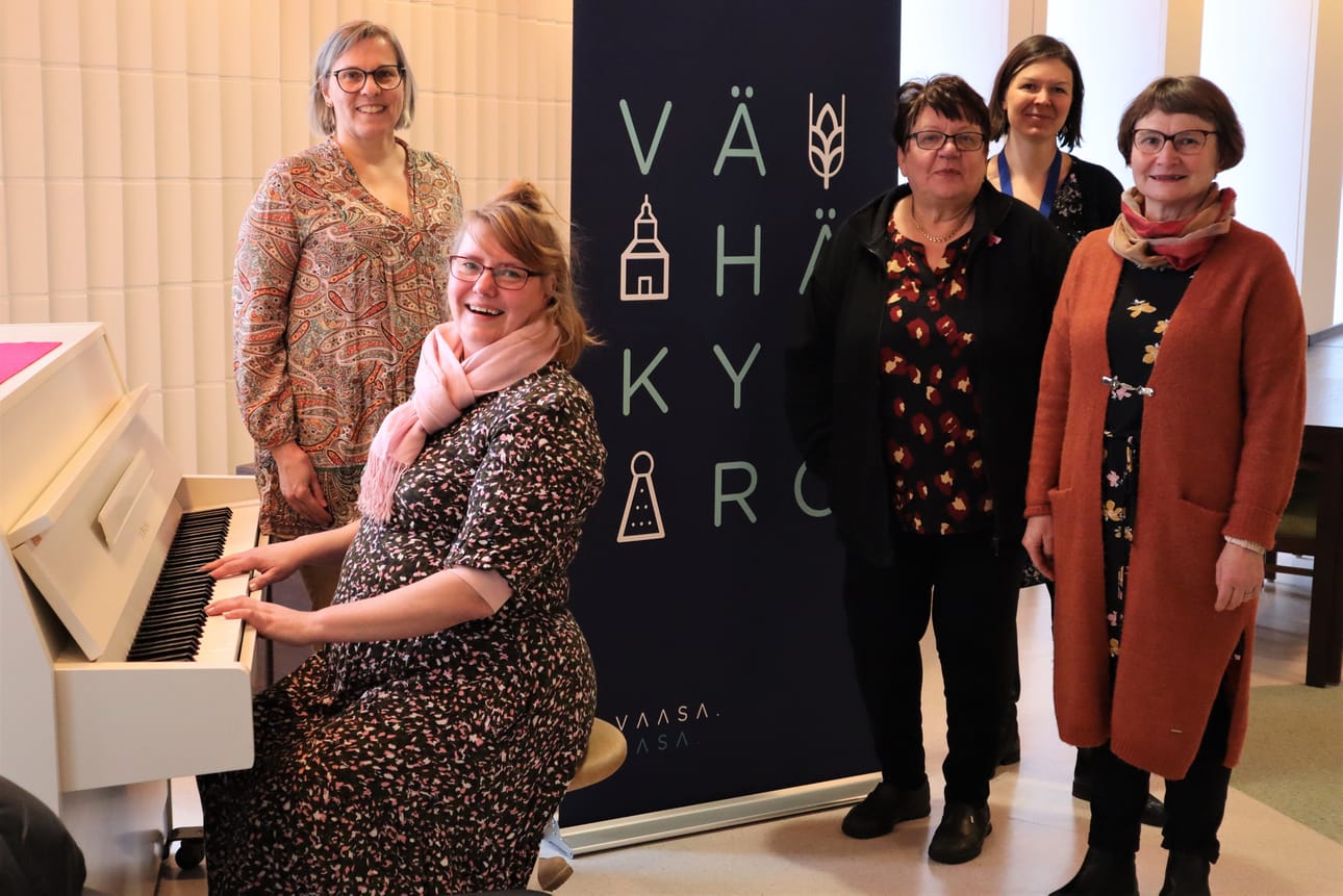 Vaasan setlementistä Anne Kytölä ja pianoa soitteleva Päivi Vauto, Eläkeliiton Vähänkyrön yhdistyksestä Anna Liisa Hakomäki ja Vaasan kaupungin kulttuuriohjaaja Heli Hokkanen järjestävät yhdessä Vähänkyrön aluepalvelupäällikön Suvi Ahon (takana) kanssa senioriolkkaritoimintaa Vähäänkyröön.