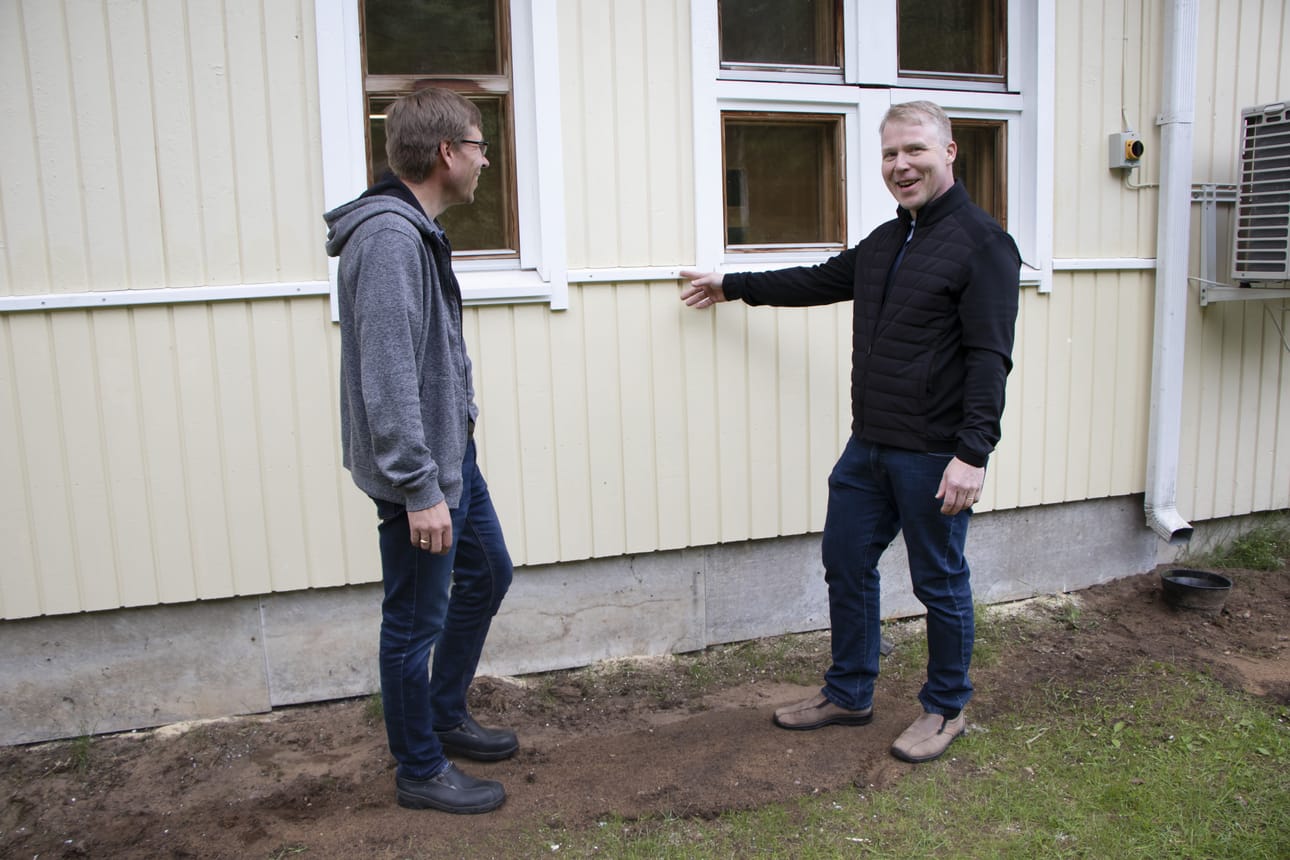 Markku Heikkala ja Ahola Hannu tarkastelemassa Murron rauhanyhdistyksen uutta ulkoilmettä. Vaakarima kertoo, mihin saakka seinän alaosaa on uusittu.