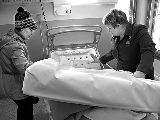 2000-luvun sairasvuode. Johtava hoitaja Sinikka Soukka (oik.) esitteli uuden vuodeosaston tiloja. Potilasvuoteen säätäminen tapahtuutv-kapulaa muistuttavalla laitteella, mikä teki Leena Haapalehtoon suuren vaikutuksen.