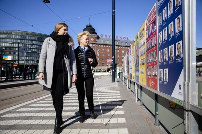 Kynnys ry:n toiminnanjohtaja, näkövammainen Merja Heikkonen ja avustaja Katja Hakasalo tutustuivat Hakaniemen torin vieressä oleviin vaalimainoksiin Helsingissä viime viikolla. Vammaisten oikeuksia puolustavat tahot saavat yhä joka vaaleista palautetta, että on tapahtunut selkeää syrjintää. KUVA: Joel Maisalmi