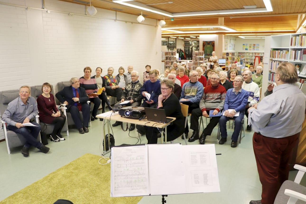 Komilaisen illan alkajaisiksi vetäistiin yhteislauluna ”Huopikkaat” monikielisesti – koska Komin pääkaupunki Syktyvkarissa on huopatossutehdas. Etualalla Syktyvdienskin piirin vieraat: tulkki Sergei Gobov, kirjaston varajohtaja Ludmila Murajeva ja museonjohtaja Vladimir Murajev.