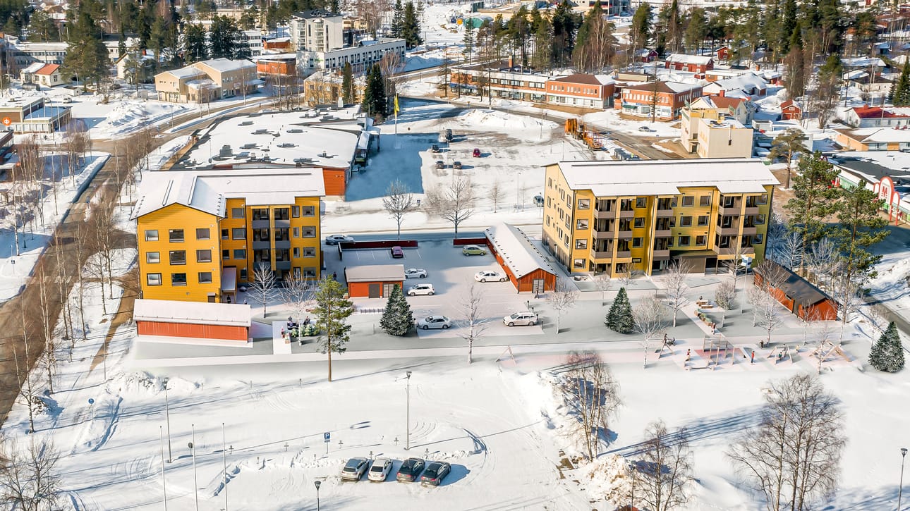 Näkymä hirsikerrostaloille kaupungintalon suunnasta. Kuvassa vasemmalla on Varsitie. Talojen sisäpiha avautuu kaupungintalon suuntaan, jossa on myös kaistale vihreää puistomaista aluetta.