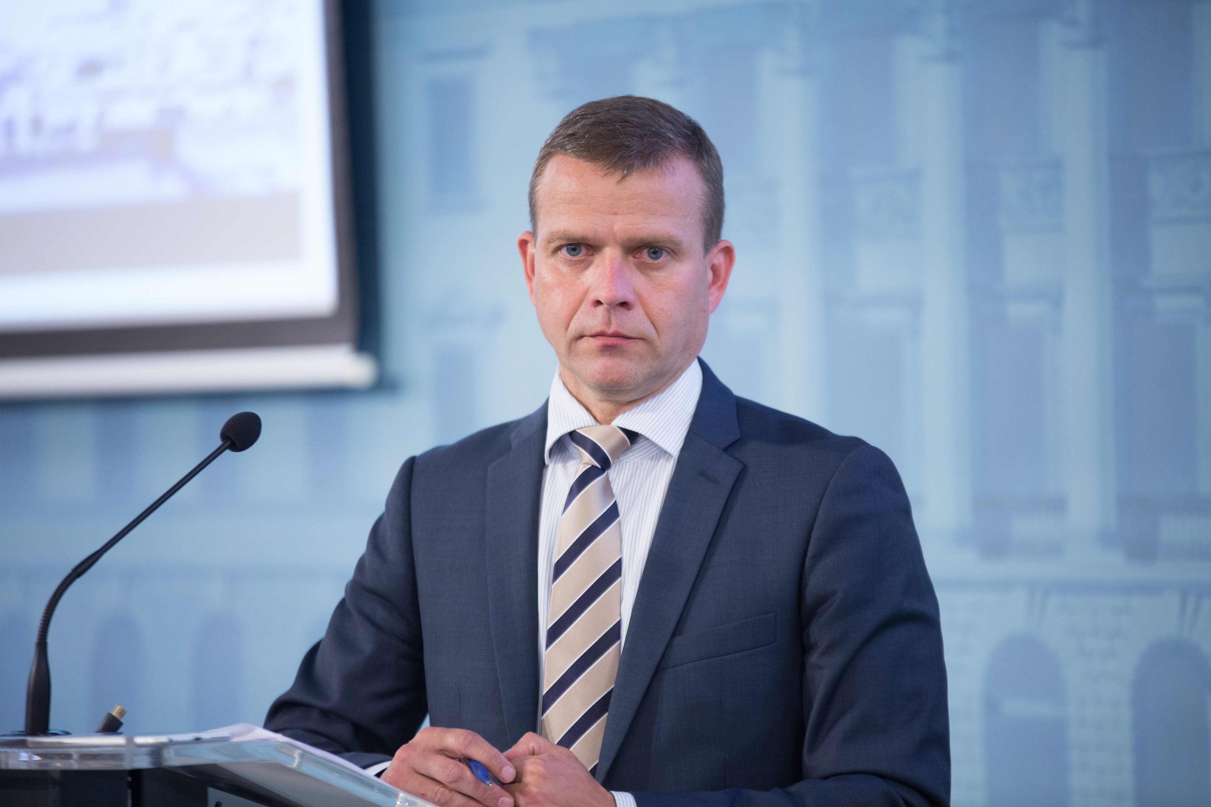 Valtiovarainministeri Petteri Orpo (kok.) ihmettelee juhlarahan kuvaa. 