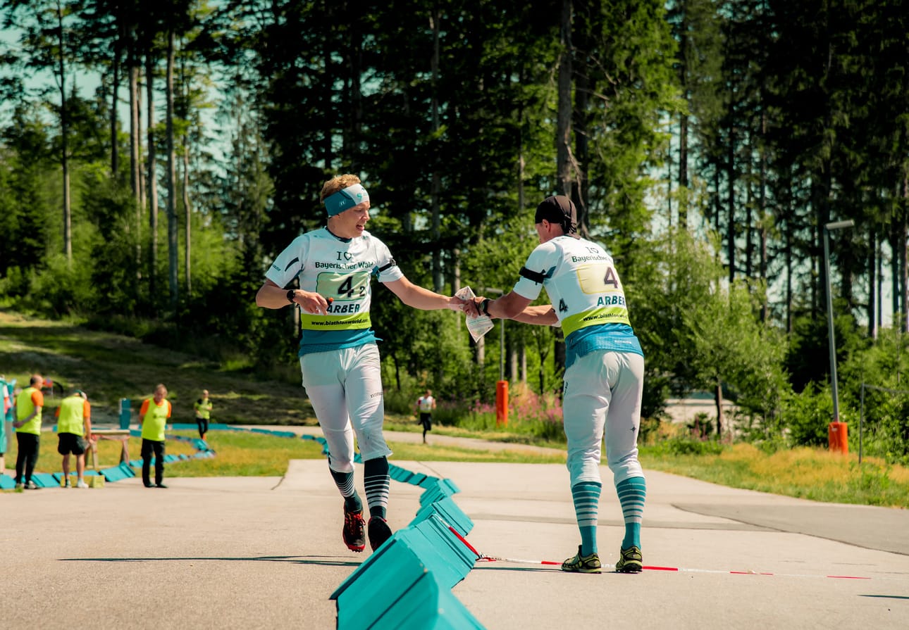 Niko Latva (vas.) tuo Suomen kakkosjoukkueen viestin Markus Salolle ampumasuunnistuksen MM-kisoissa Saksassa.