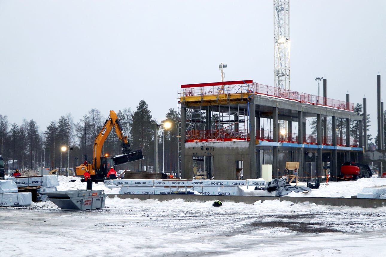 Kontion hirret saapuivat Hyvän olon keskuksen työmaalle tiistaiaamuna (kuva vasemmalla). Rakennukset salvetaan betonisen rungon päälle osasto kerrallaan (kuva oikealla). Lopuksi päälle nostetaan lohkoina maassa rakennettu katto.