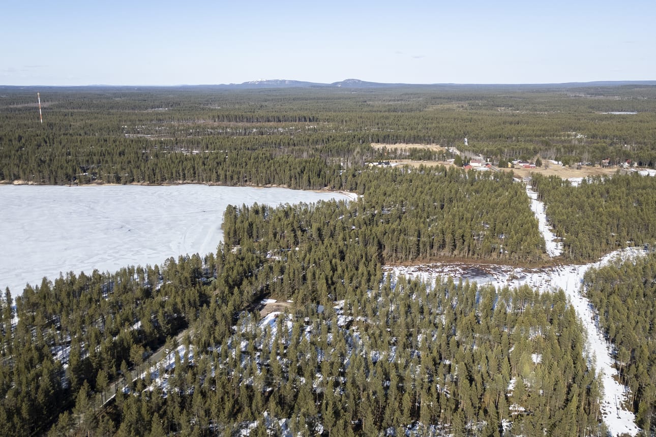 Oivankia kuvattuna koillisen suuntaan Oivanginjärven ja Singerjärven (vasemmalla) väliltä torstaina. Vasemmalla kulkee Junganharjuntie oikealle kyläkeskukseen. Horisontissa on Rukatunturi ja Pyhävaara noin 12 kilometrin päässä.