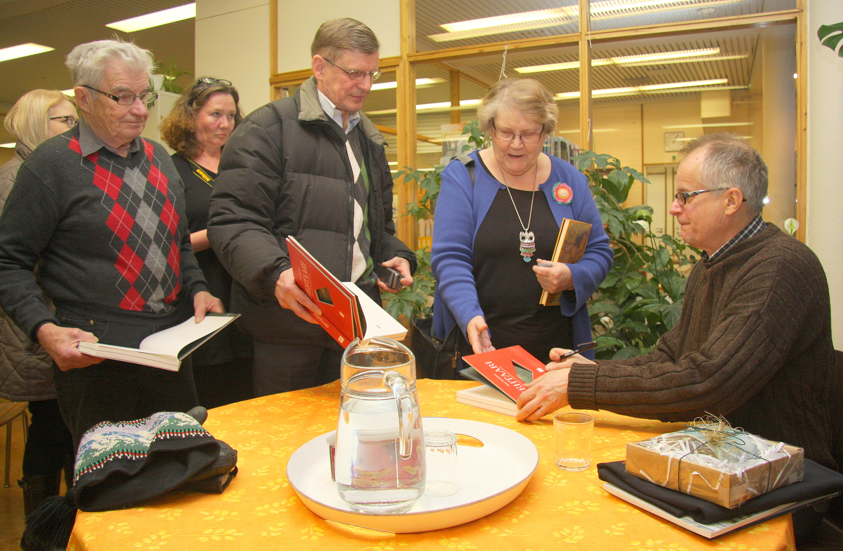 Ilkka Malmberg (oik.) signeerasi kirjoja Posiolla 2012.