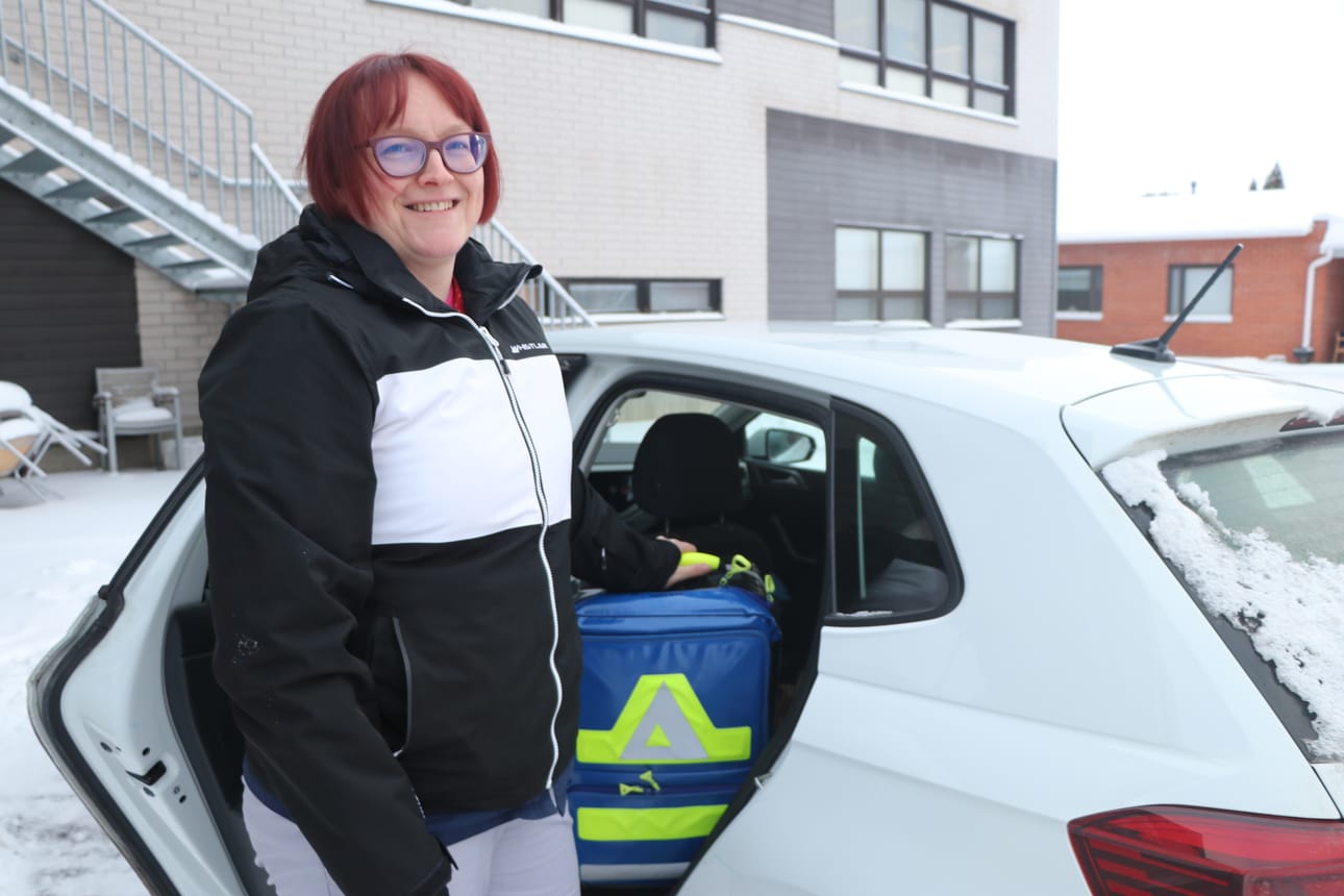 Sairaanhoitaja Pauliina Pylkkönen reppuineen vie apua moneen kotiin.