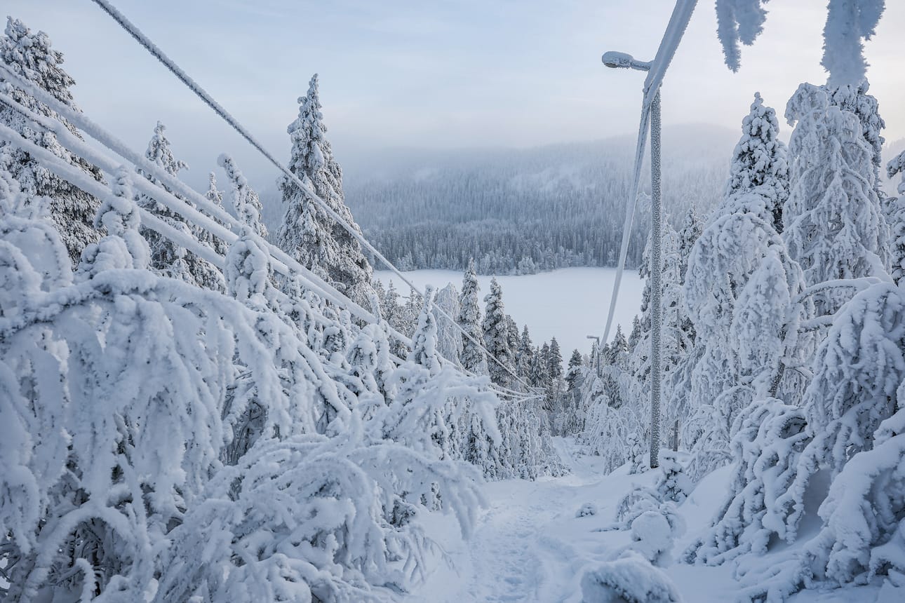 Pakkohuutokaupattavalla maapalstalla seisoo vanha hiihtohissi vaijereineen ja valopylväineen. Taustalla näkyy Valtavaaran vaarajono ja jääpeitteinen Yli-Pessari-järvi.
