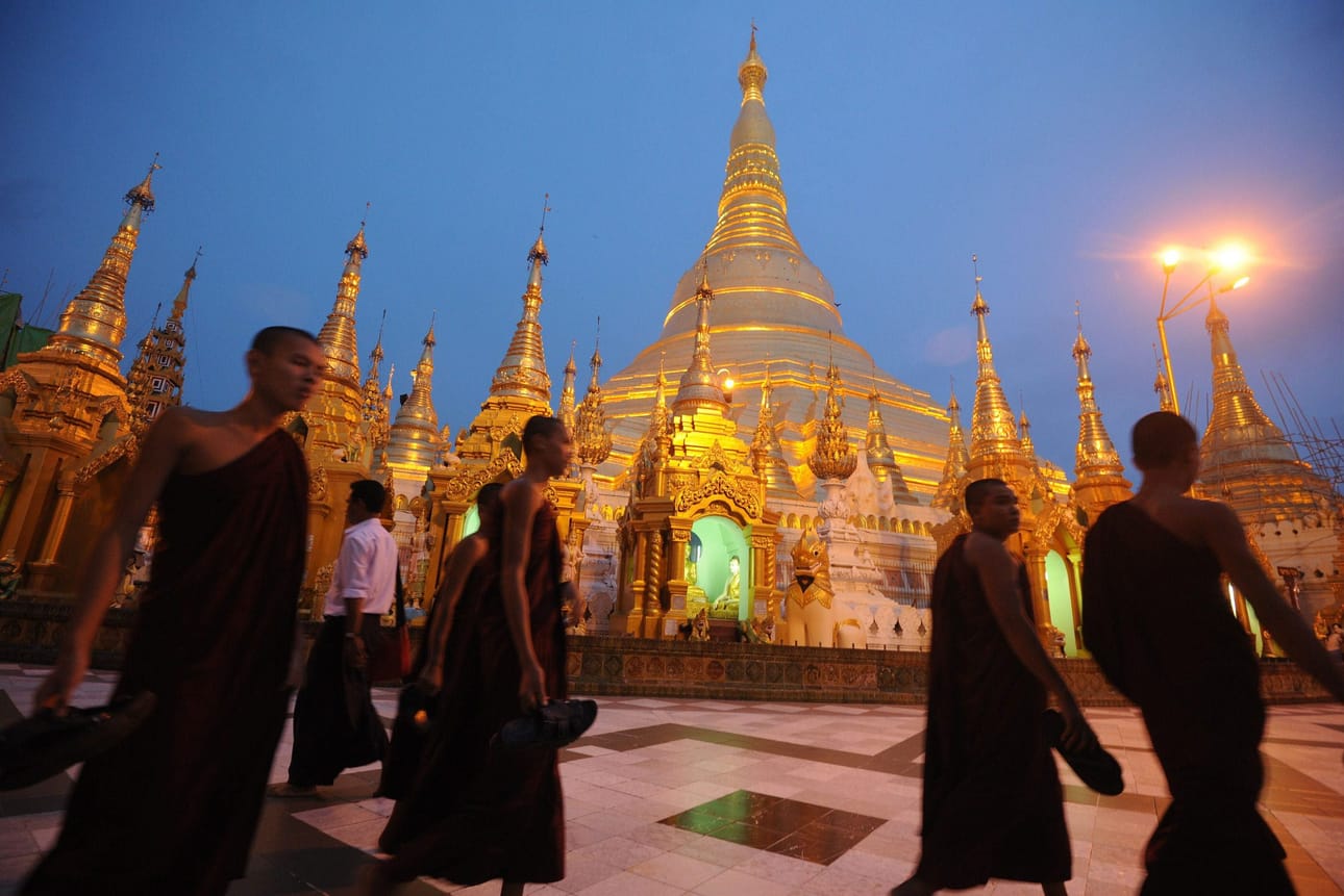 Buddhalaismunkit kävelevät ympäriShwedagon Pagodan katedraalia Rangoonissa.