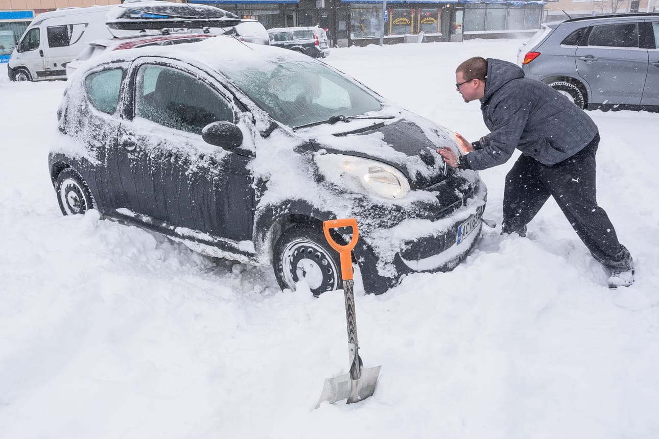 Jesse Manninen työntää Markku Mäkelän autoa lumentulon jälkeen.