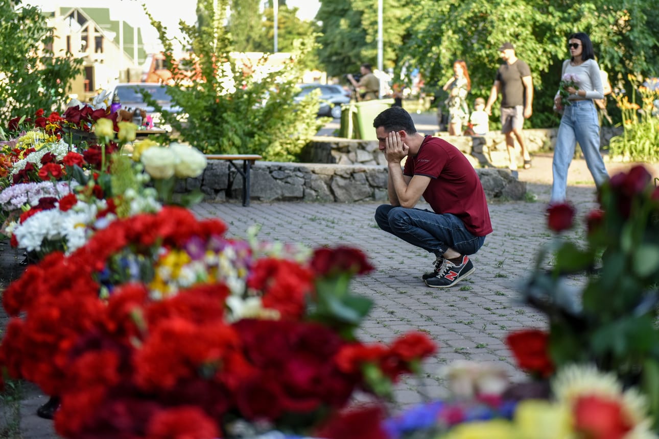Ihmiset toivat kukkia Krementshukin ostoskeskukseen kohdistuneessa iskussa kuolleiden muistoksi.