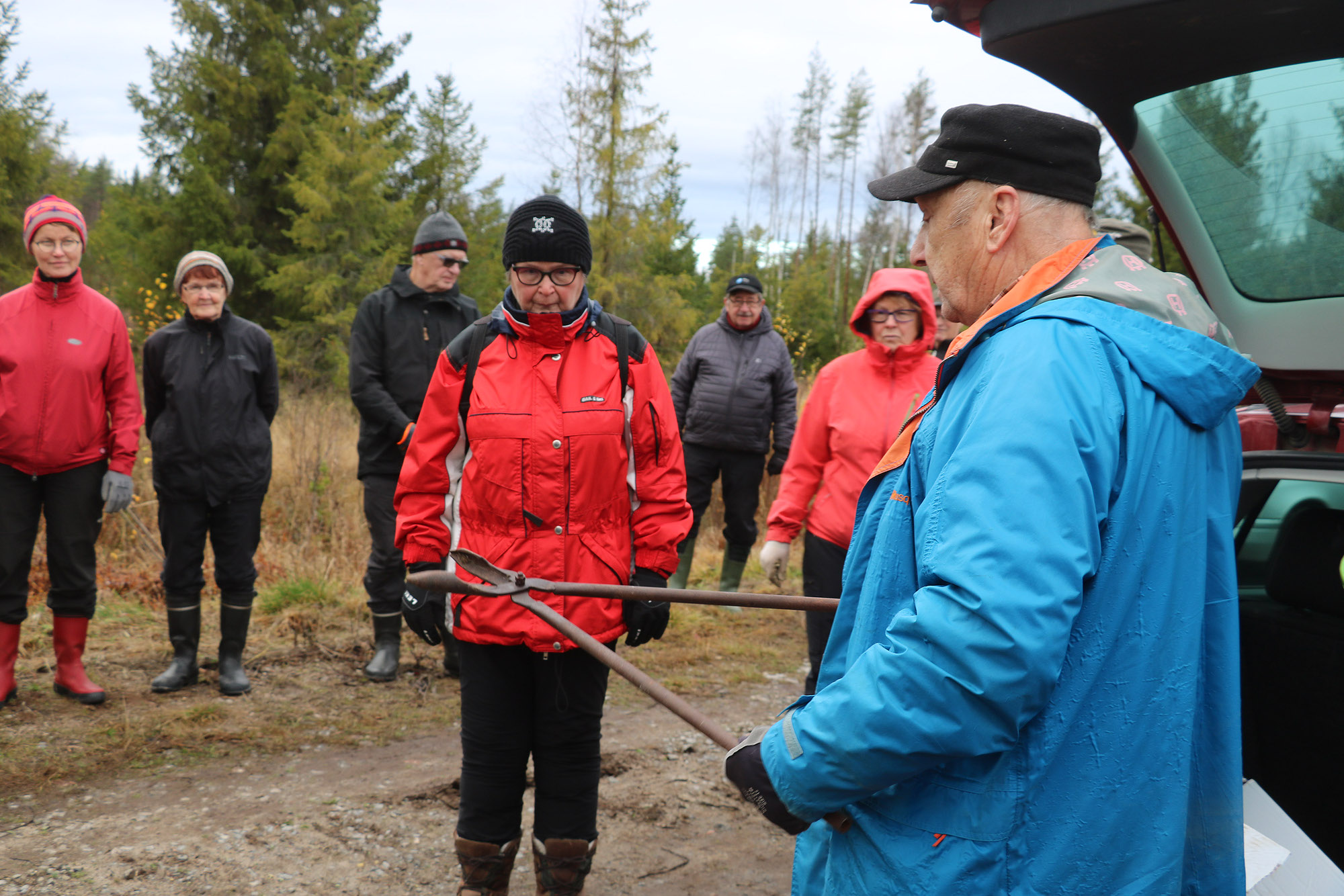 Sauli Takalo toimi isäntänä istutustempauksessa. Hän esitteli vanhaa työvälinettä Oulaisten yhdistyksen puheenjohtaja Kaija Seposelle ja muille eläkeliittolaisille. Paikalla oli runsaasti osanottajia.