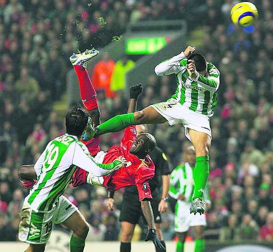 Ilmalentoja. Liverpoolin Mohamed Sissoko (kesk.) ja Real Betisin Oscar Lopez (vas.) ja Juanito Gutierrez.