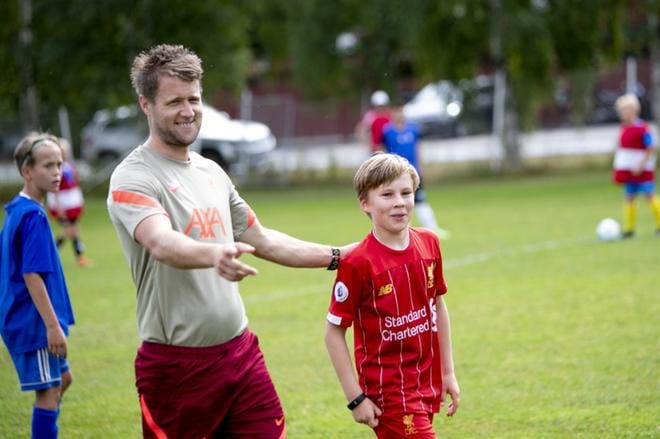 Matias Landon, 11, saapui Rovaniemeltä pikkuveljensä kanssa leirille, koska on suuri Liverpoolin kannattaja. Päävalmentaja Daniel Mapp-Jones hassuttelee vieressä ja pyytää nuorelta jalkapalloilijalta nimikirjoitusta haastattelun jälkeen. Taustalla harjoittelee Johannes Mäkelä. Kuvat:Jaakko Elenius