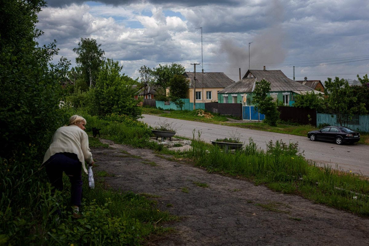 Nainen pyrki suojaan tykistötulelta keskiviikkona kylässä lähellä Harkovan suurkaupunkia. LEHTIKUVA / AFP