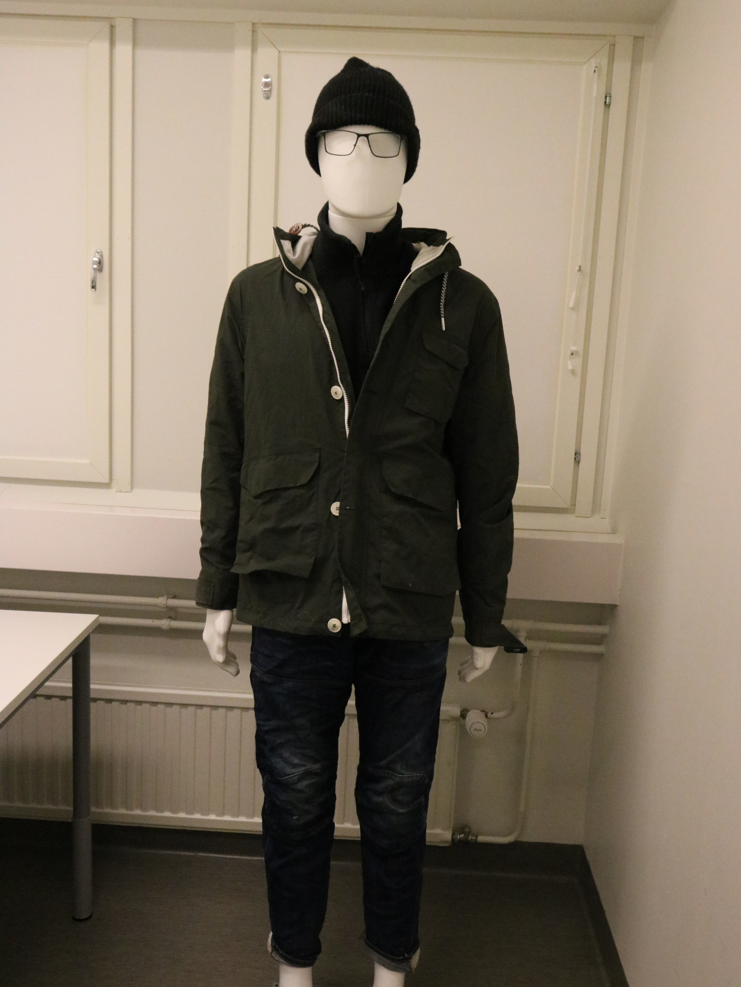 Vainajan yllä olleet ulkovaatteet ja silmälasit.