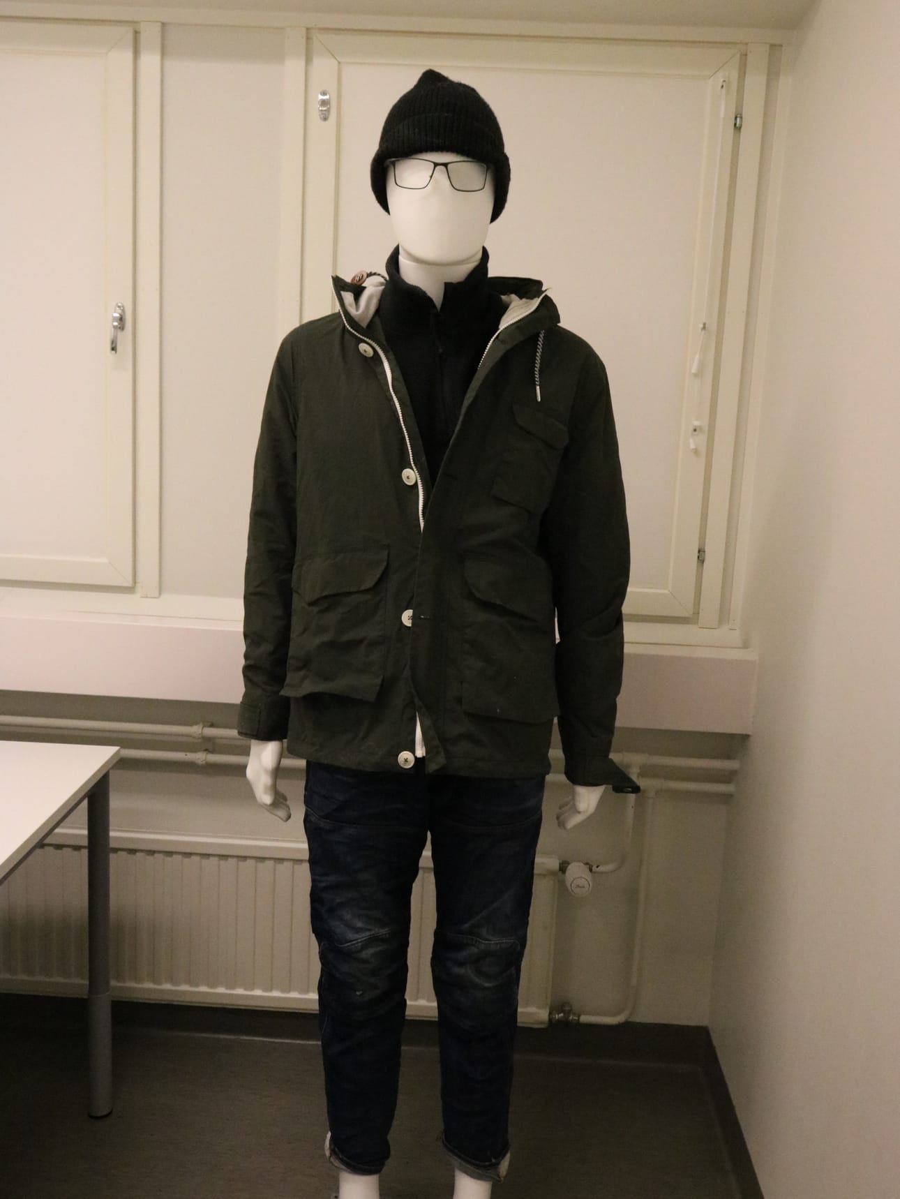 Vainajan yllä olleet ulkovaatteet ja silmälasit.