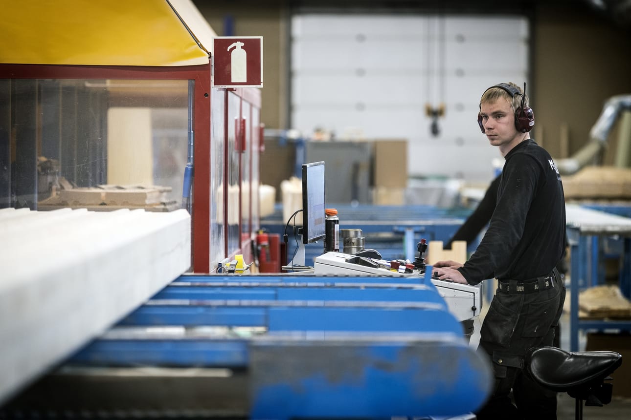 Benjami Nylander valvoo Mammuttikotien tehtaalla Ylikiimingissä, että kone sahaa hirret oikein.