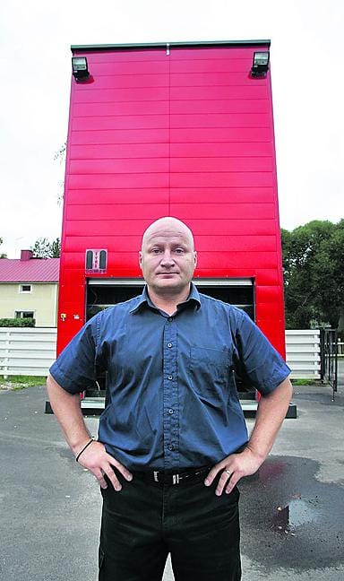 K-rengas ja huolto Oy:n rengasasentaja Markku Helanen nostaa asiakkaan renkaita tavarakontista.