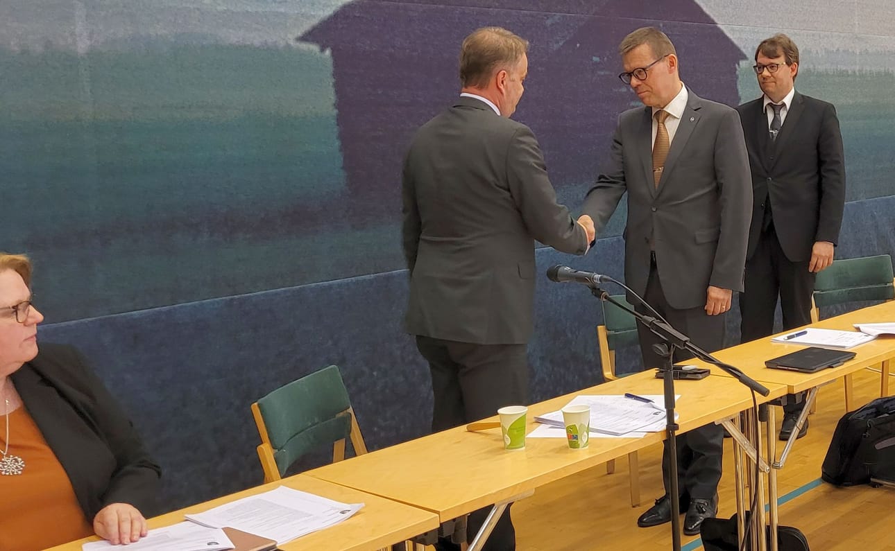 Valtuuston puheenjohtaja Janne Sankelo ja kaupunginjohtaja Markku Lumio kättelivät Lumion irtisanoutumispykälän päätteeksi Kauhavan kaupunginvaltuustossa kesäkuussa 2022. Taustalla kaupunginhallituksen puheenjohtaja Teemu Hakala.