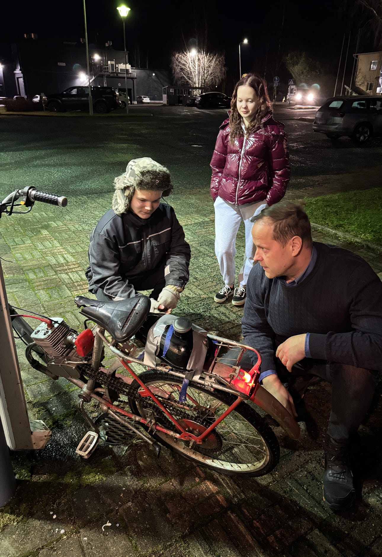 Vinski Saastamoinen ja Katariina Haikola yllättyivät iloisesti, kun Siikalatvan kunnanjohtaja Pekka Iivari tuli auttamaan nuoria Vinskin moottoroidun polkupyörän rengasrikon korjaamisessa. Iivari mietti hetken, kuinka auttaa nuoria.