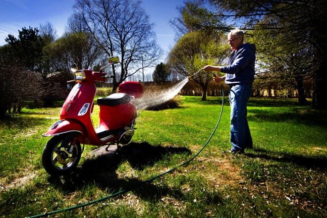 Seppo Rapo hoitaa Vespa-skootterin ajokuntoon kotipihalla Vaasan Kråklundissa. Kuva: Eetu Sillanpää
