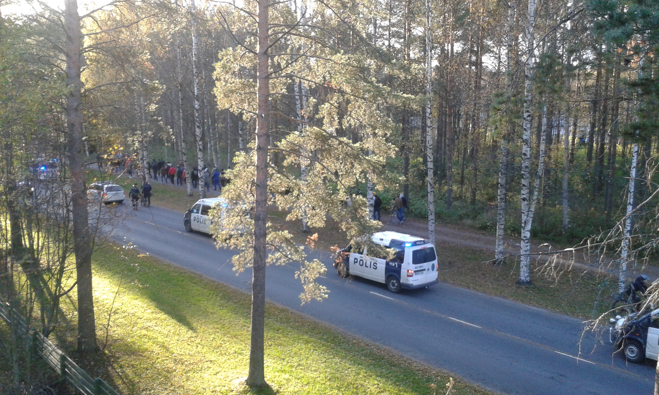 Lukijankuvassa näkyy mielenosoittajien joukko sekä poliisisaattue.