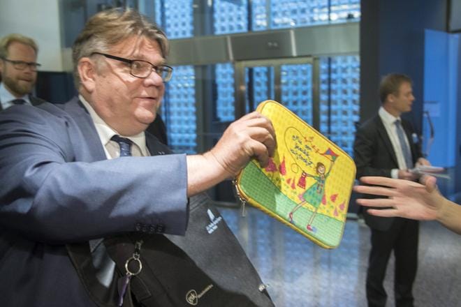 Ulkoministeri Timo Soini antoi läppärilaukkunsa avustajalleen ennen suurlähettiläskokouksen alkamista Helsingissä maanantaina. KUVA: Mauri Ratilainen