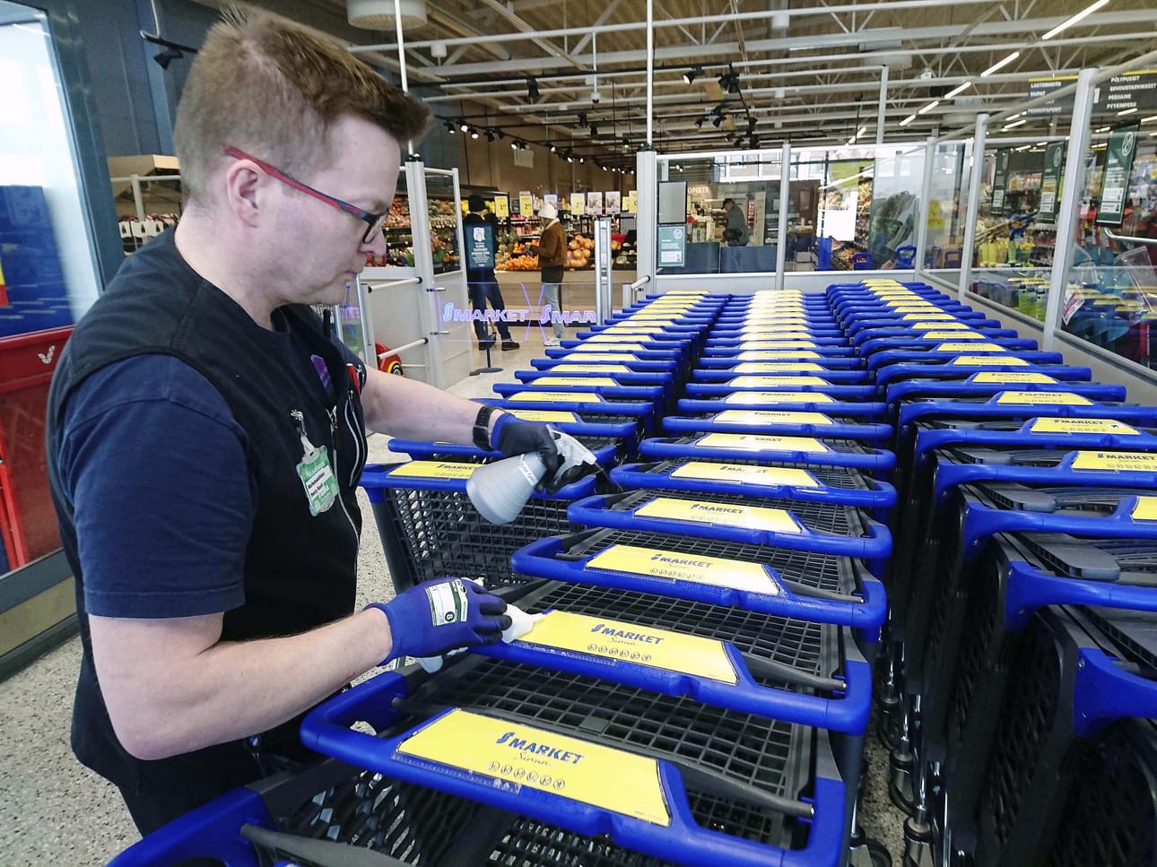 INARI. S-market Vaskoolin päällikkö Henry Kesti desinfioi ostoskärryjä. Operaatio toistuu monta kertaa päivässä.