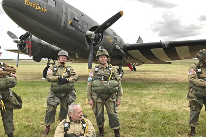 Seinäjokelainen Heikki Pennala (keskellä) seisoo Douglas C-47 -hyppykoneen edessä. Mies on pukeutunut toisen maailmansodan aikaisen amerikkalaisen taistelijan varusteisiin. Pennalan vasemmalla puolella hyppyä odottaa Porvoon seudun laskuvarjojääkärikiltalainen Jukka Jokinen. KUVAT: HEIKKI PENNALAN KOKOELMA