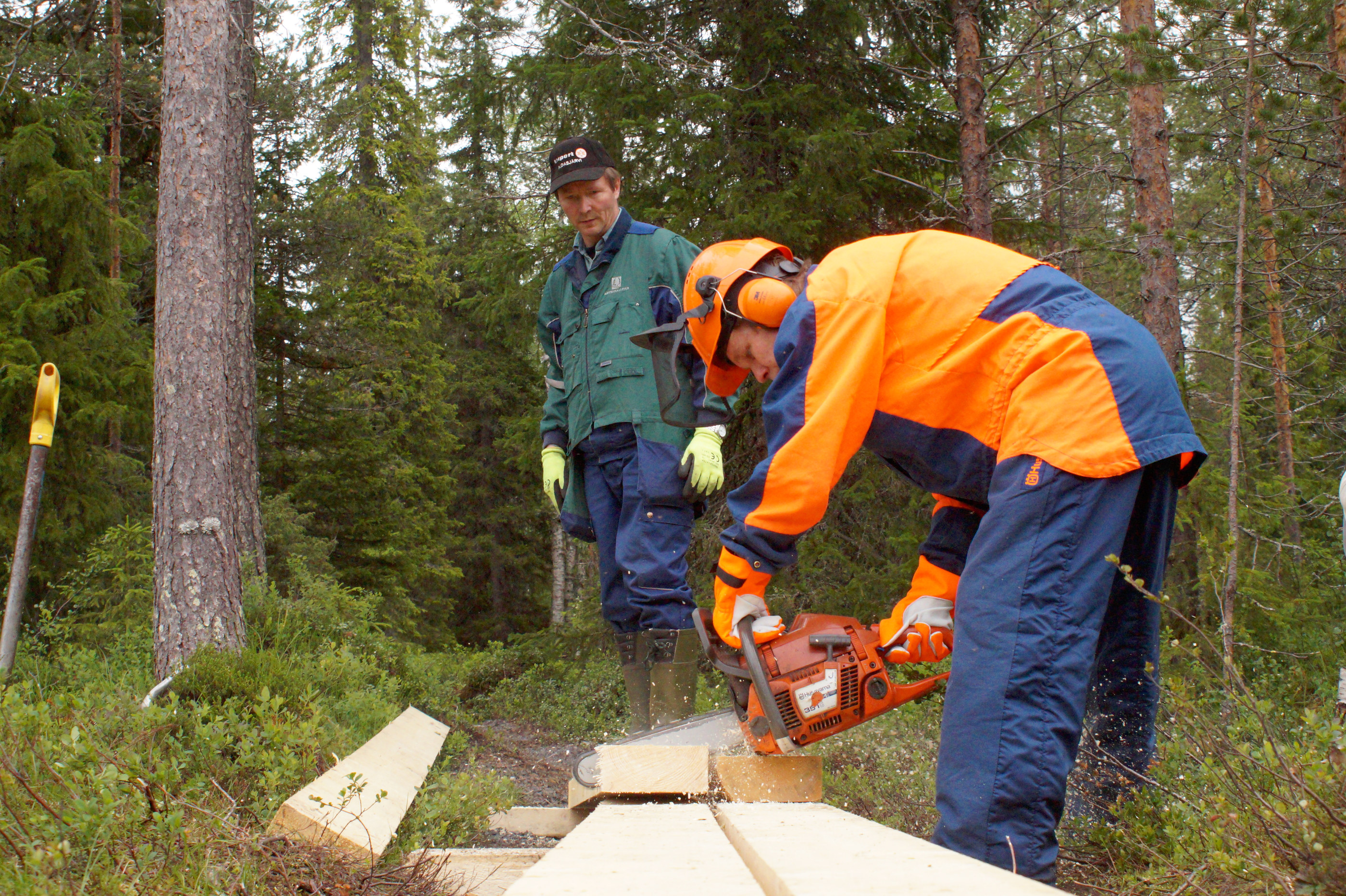 Kauko Teeriniemi tekee sahalla millintarkkaa työtä, Jussi Tuomivaaran osuus on iskeä pitkoslankut kiinni aluspuihin.