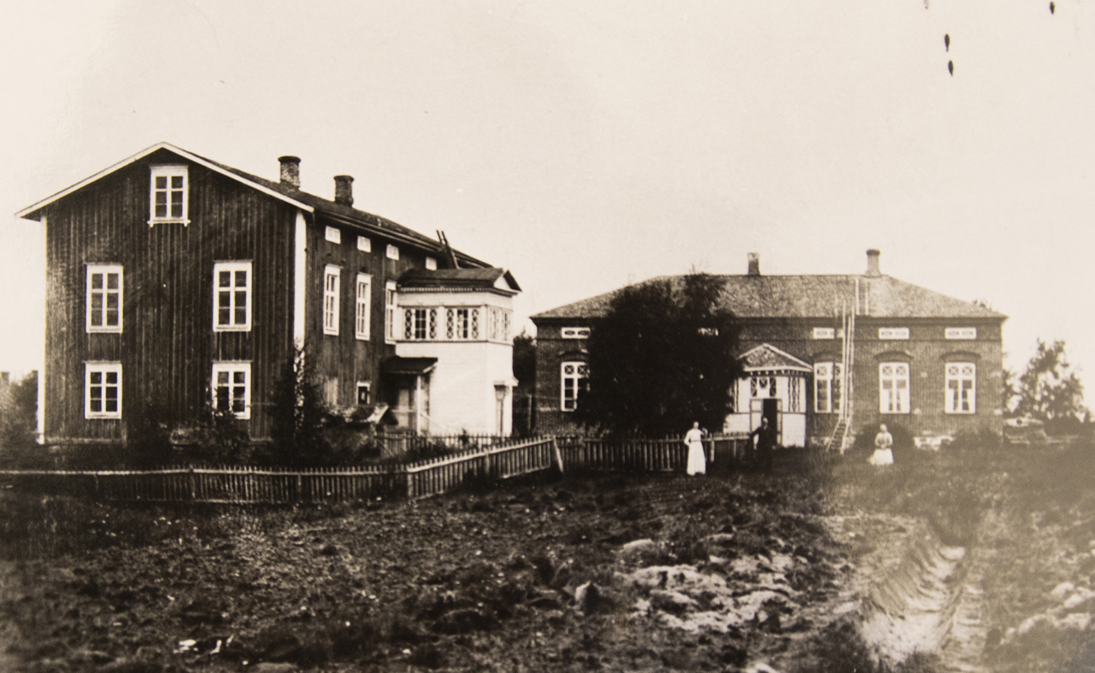 <p>Vanha kaksikerroksinen puukoulu on ollut näyttävä rakennus. Kivikoulu on kuvassa tiilipinnalla, mutta se on myöhemmin rapattu. </p>