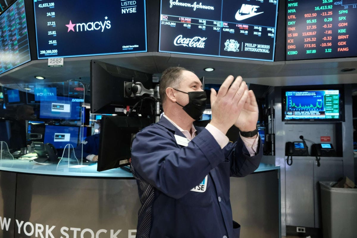 Välittäjä taputti käsiään, kun Dow Jones -indeksi kipusi plussan puolelle maanantaina New Yorkin pörssissä. LEHTIKUVA / AFP