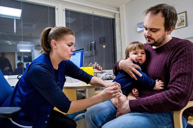 Terveydenhoitaja Jenna Lindqvist antaa rokotteen Petteri Koivumäen pojalle. Koivumäen mukaan hänen tuttavapiirissään kaikki antavat rokotuttaa lapsensa. KUVAT: CLAS-OLAV SLOTTE